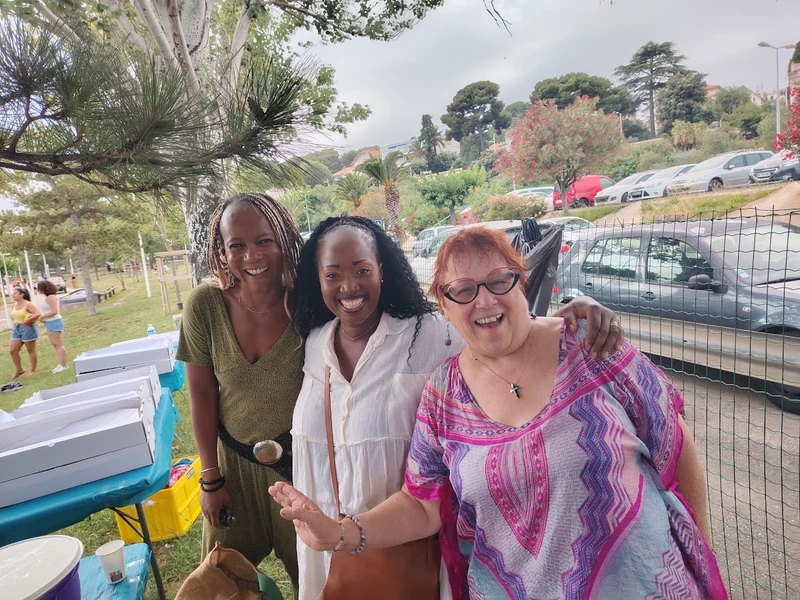 Trois participantes souriantes lors d’une rencontre en plein air.