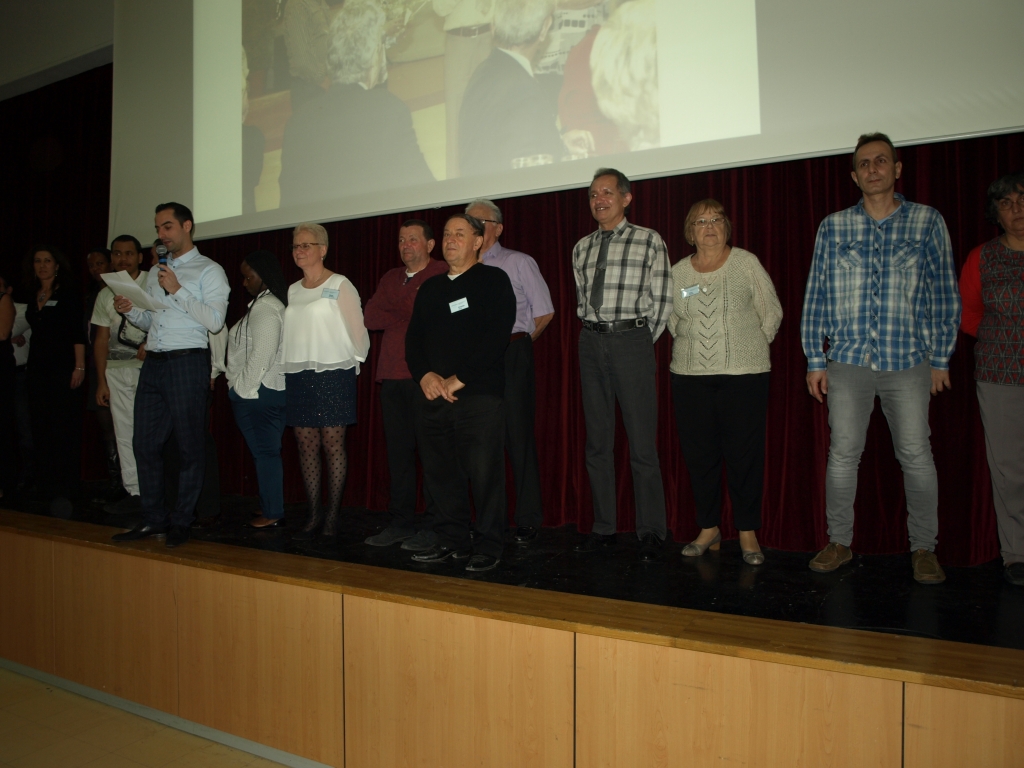 Participants alignés sur scène sous un diaporama pour les 25 ans de présidence de Pierre Marie.