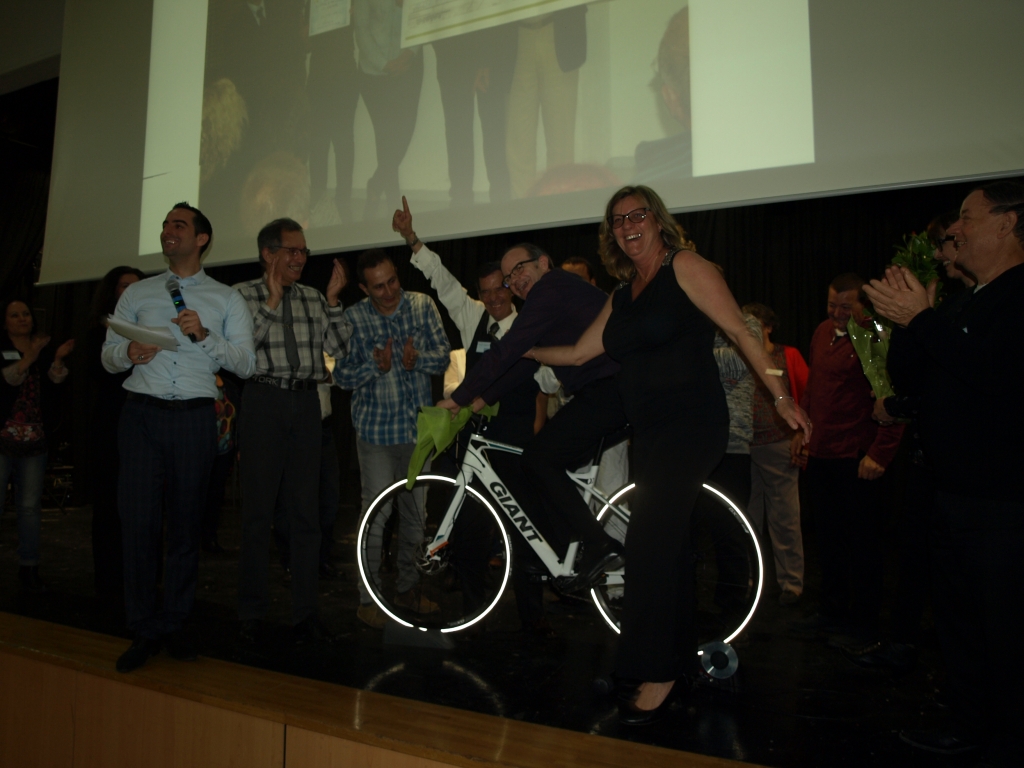 Présentation d’un vélo sur scène au milieu des participants à l’hommage.