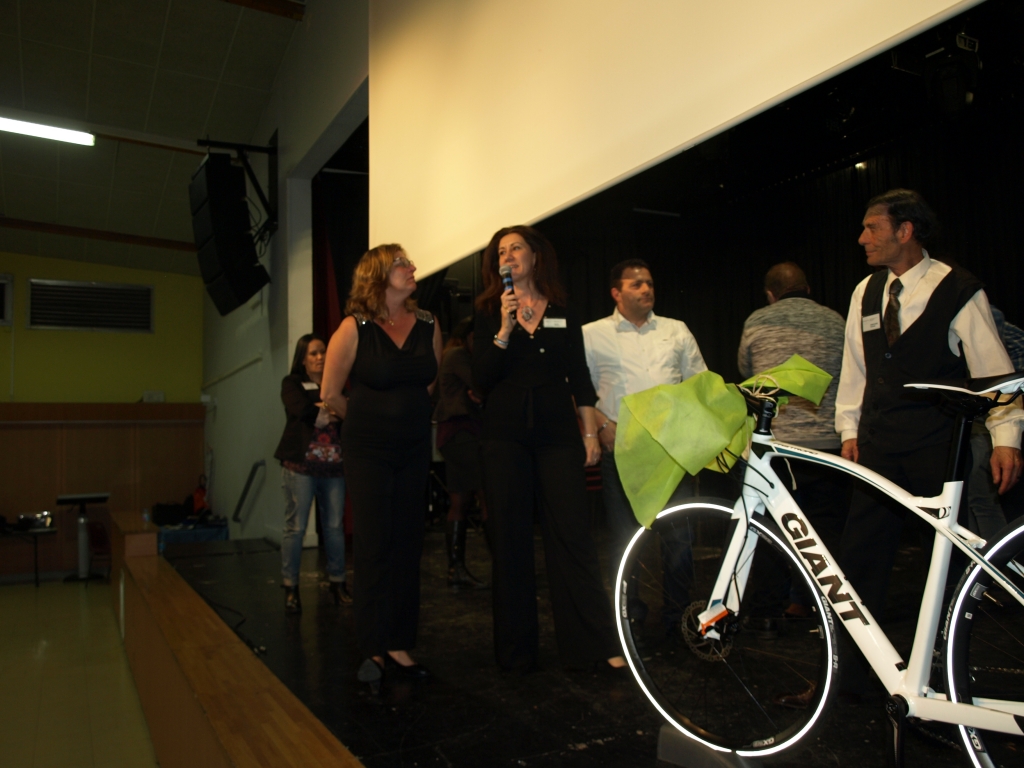 Une intervenante au micro se tient près du vélo et des autres participants.