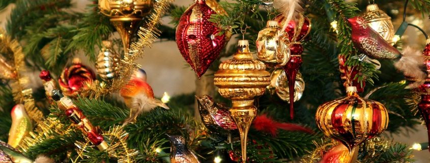 Boules rouges et dorées suspendues aux branches d’un sapin de Noël.