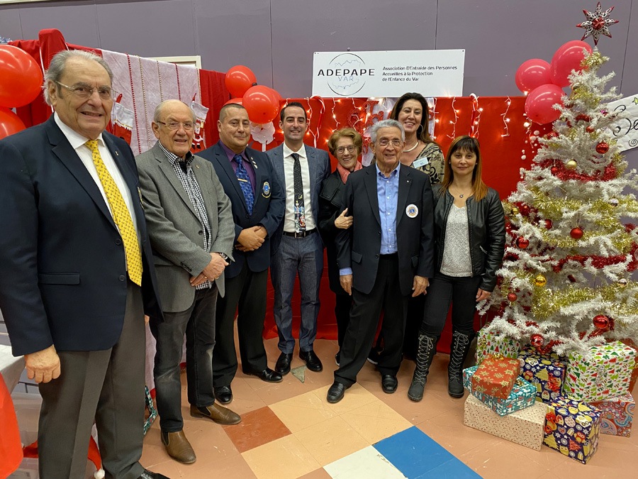 Participants réunis devant la banderole ADEPAPE et les cadeaux de Noël 2019.