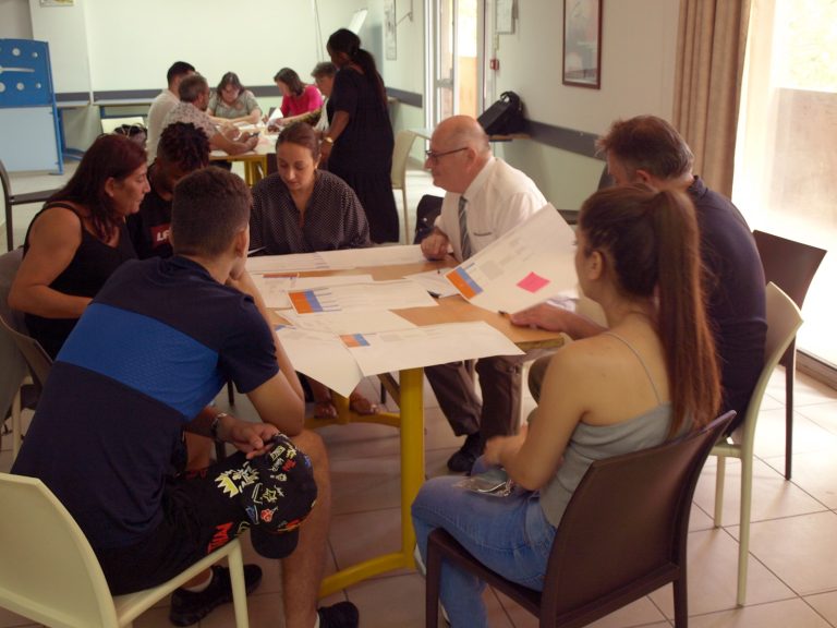 Un groupe échange autour d’une table de travail.