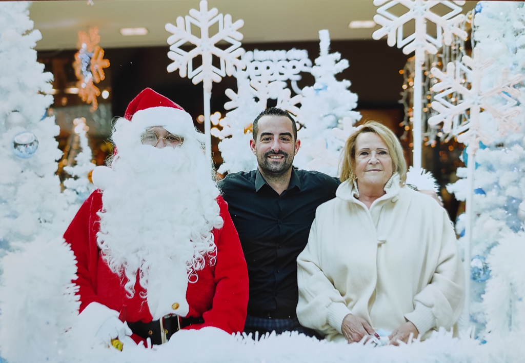 Deux participants posent avec le Père Noël dans le décor enneigé de Grand Var.