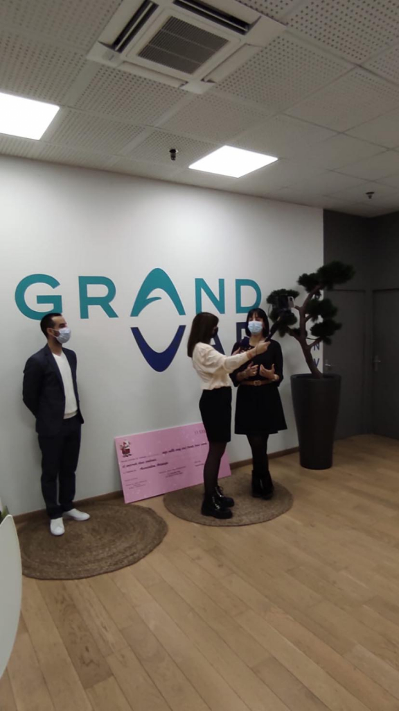 Interview devant le logo Grand Var et le chèque de l’opération Noël solidaire.