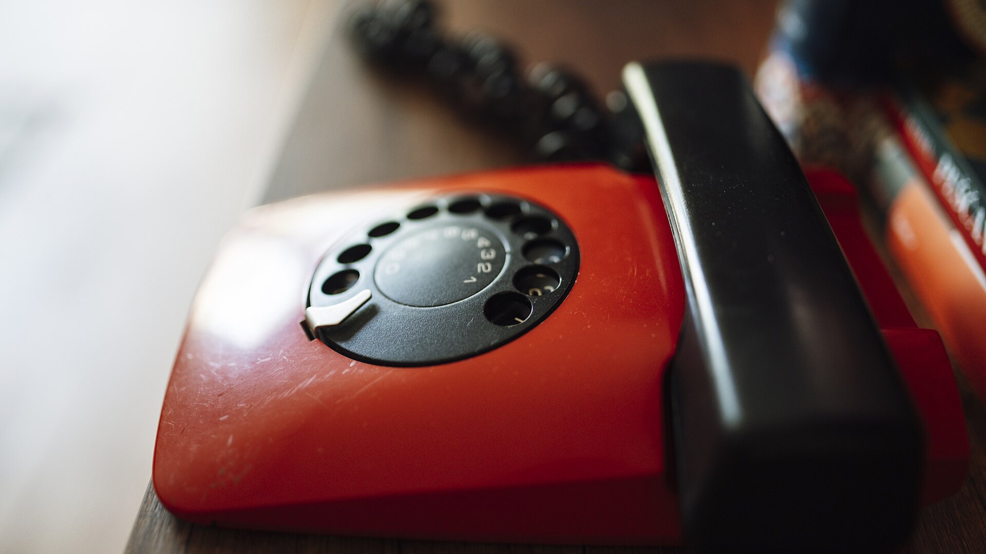 Un combiné noir posé sur un téléphone rouge.