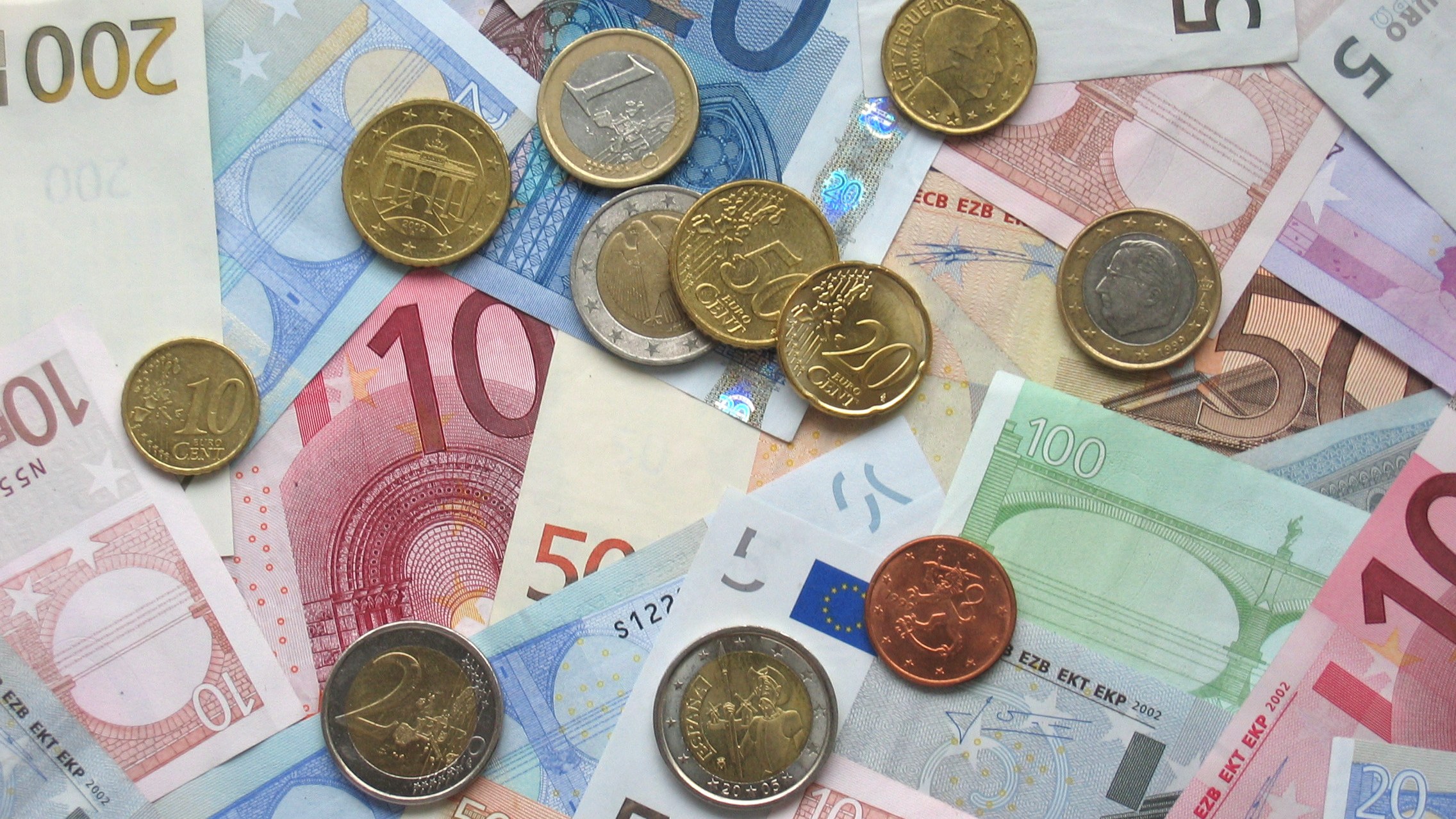 Pièces et billets en euros étalés côte à côte