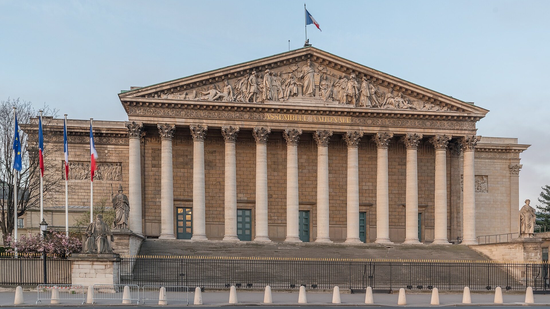 Façade à colonnes de l'Assemblée nationale (Palais Bourbon) à Paris, surmontée du drapeau français