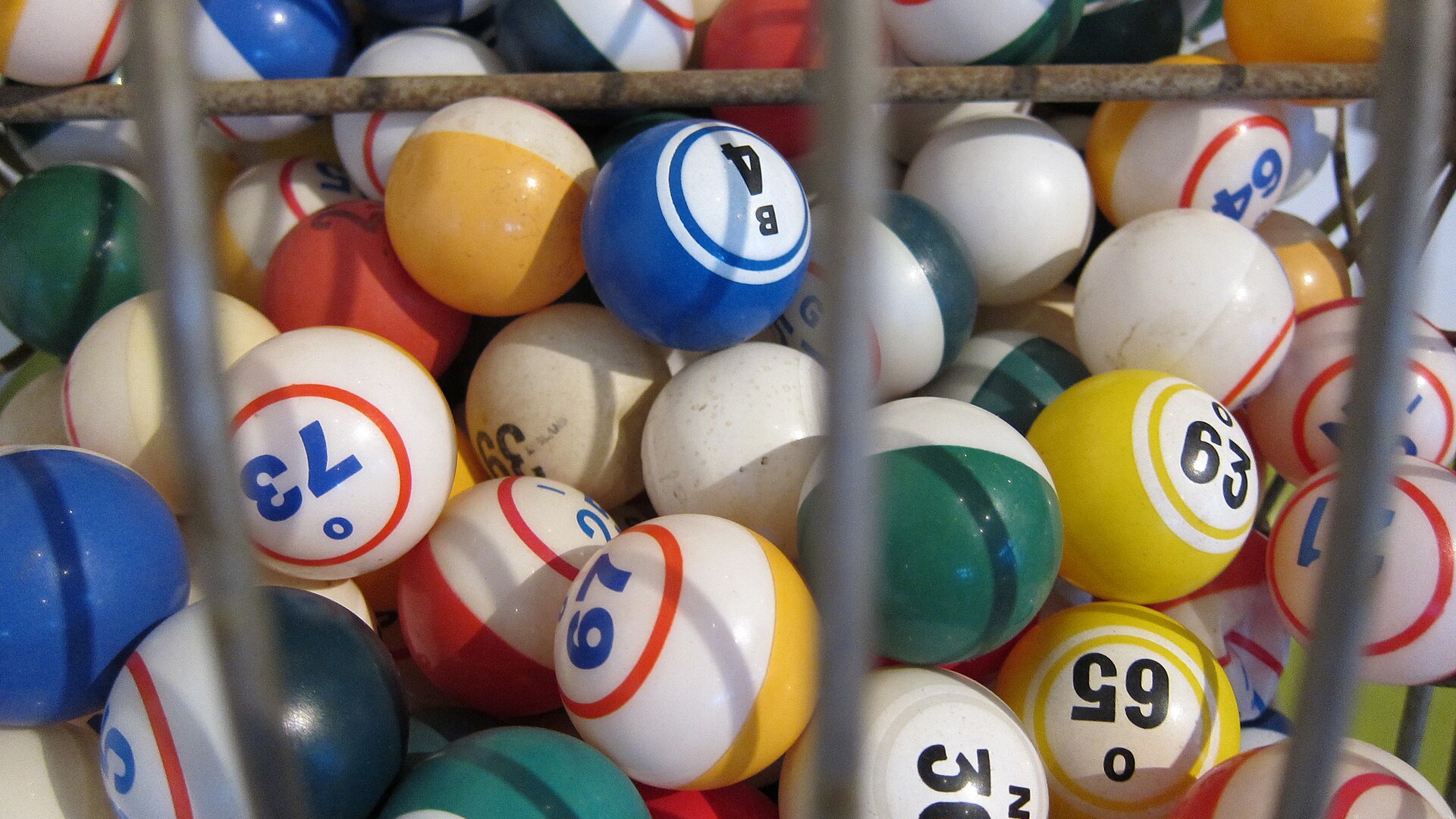 Boules de loto numerotees et colorees dans un boulier grillage