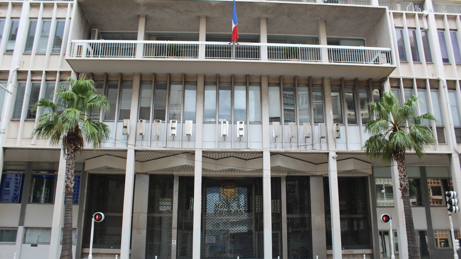 Façade de l’hôtel de ville de Toulon, avec ses fenêtres et ses drapeaux.