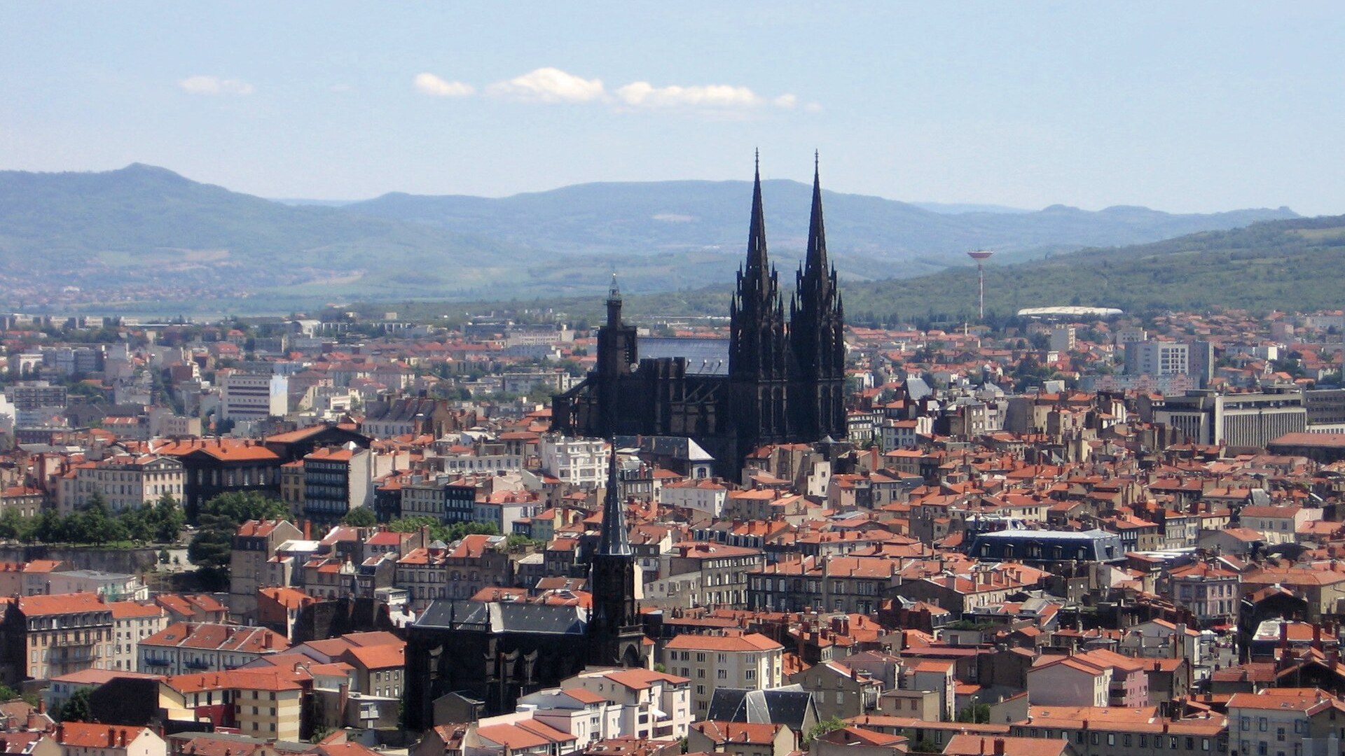Vue aérienne de Clermont-Ferrand et de sa cathédrale de pierre noire, avec les monts d'Auvergne à l'horizon