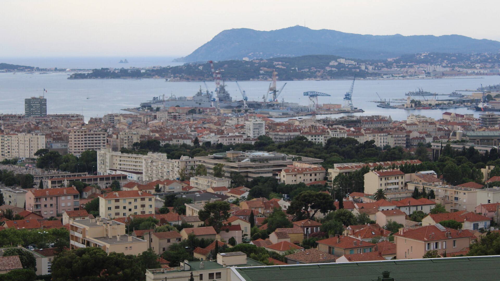 Vue générale de Toulon, chef-lieu du Var, avec ses toits, sa rade et les collines en arrière-plan