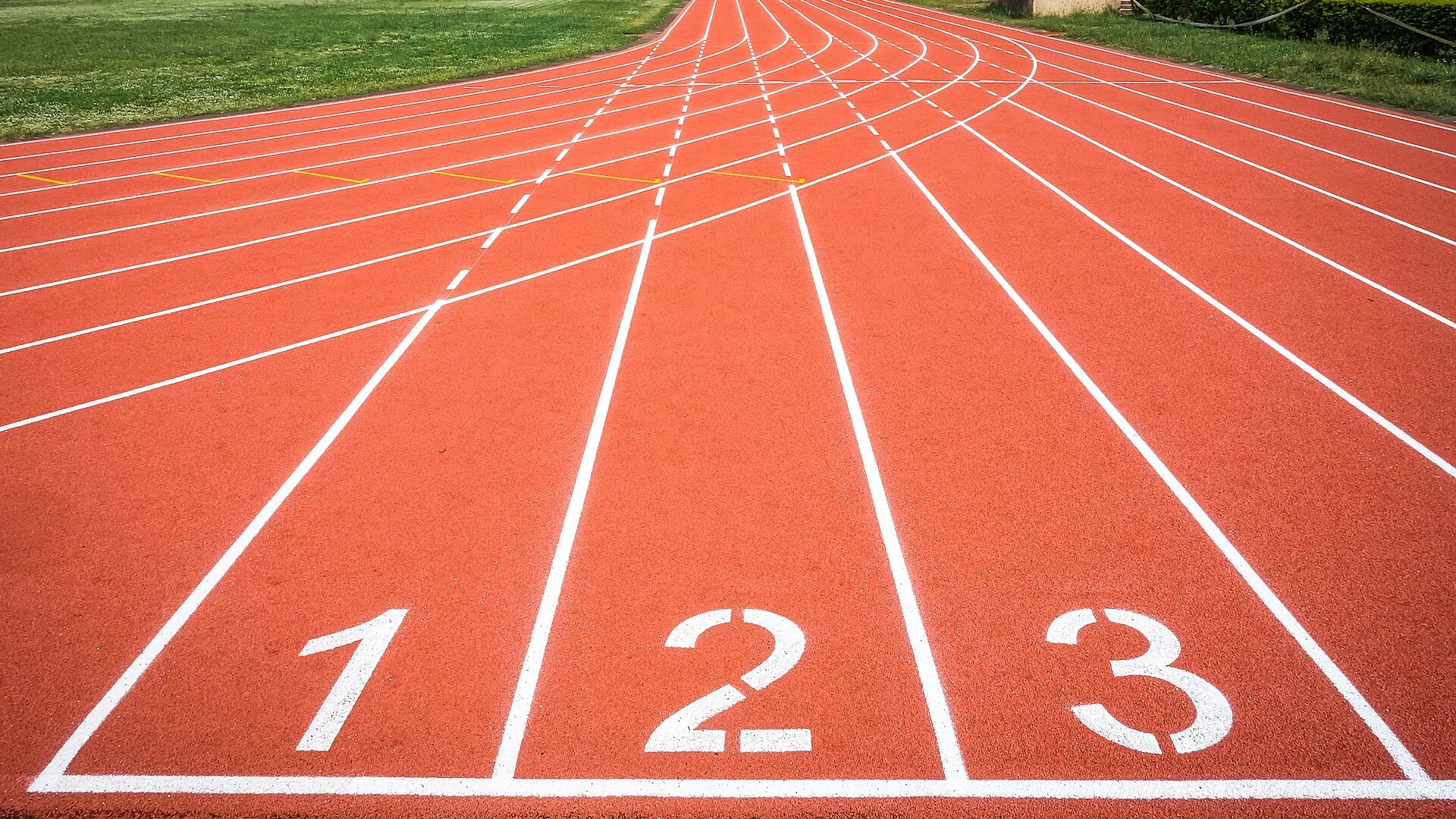 Les couloirs numérotés d’une piste d’athlétisme rouge.