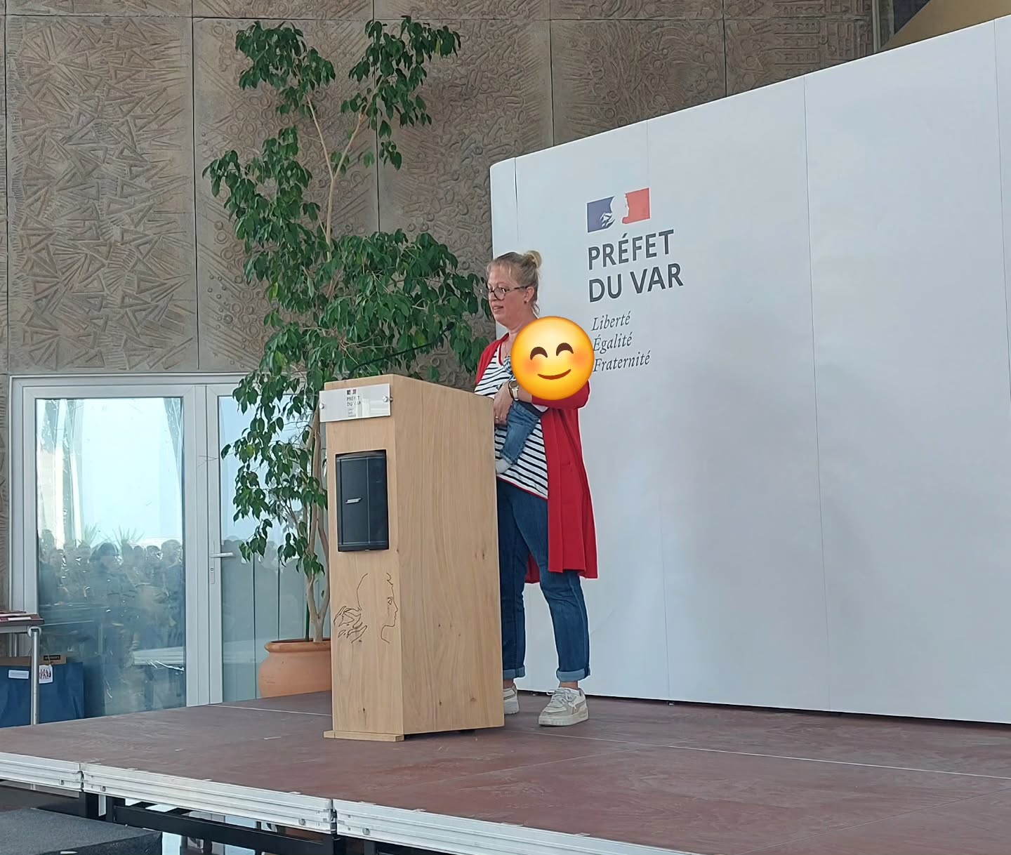 Une intervenante au pupitre devant l’inscription « Préfet du Var ».