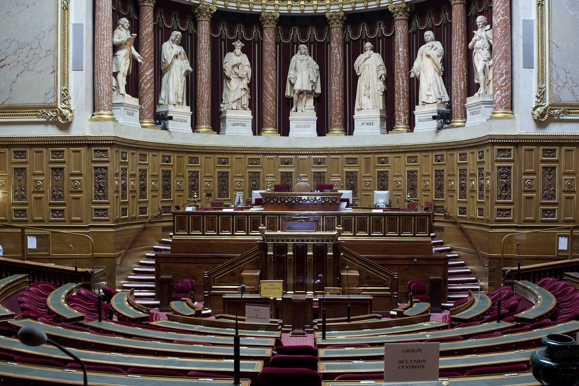 La tribune et les sièges rouges de l’hémicycle du Sénat.