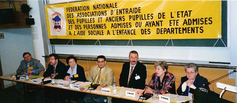 Les intervenants à une table ronde sur les origines, sous la bannière fédérale.