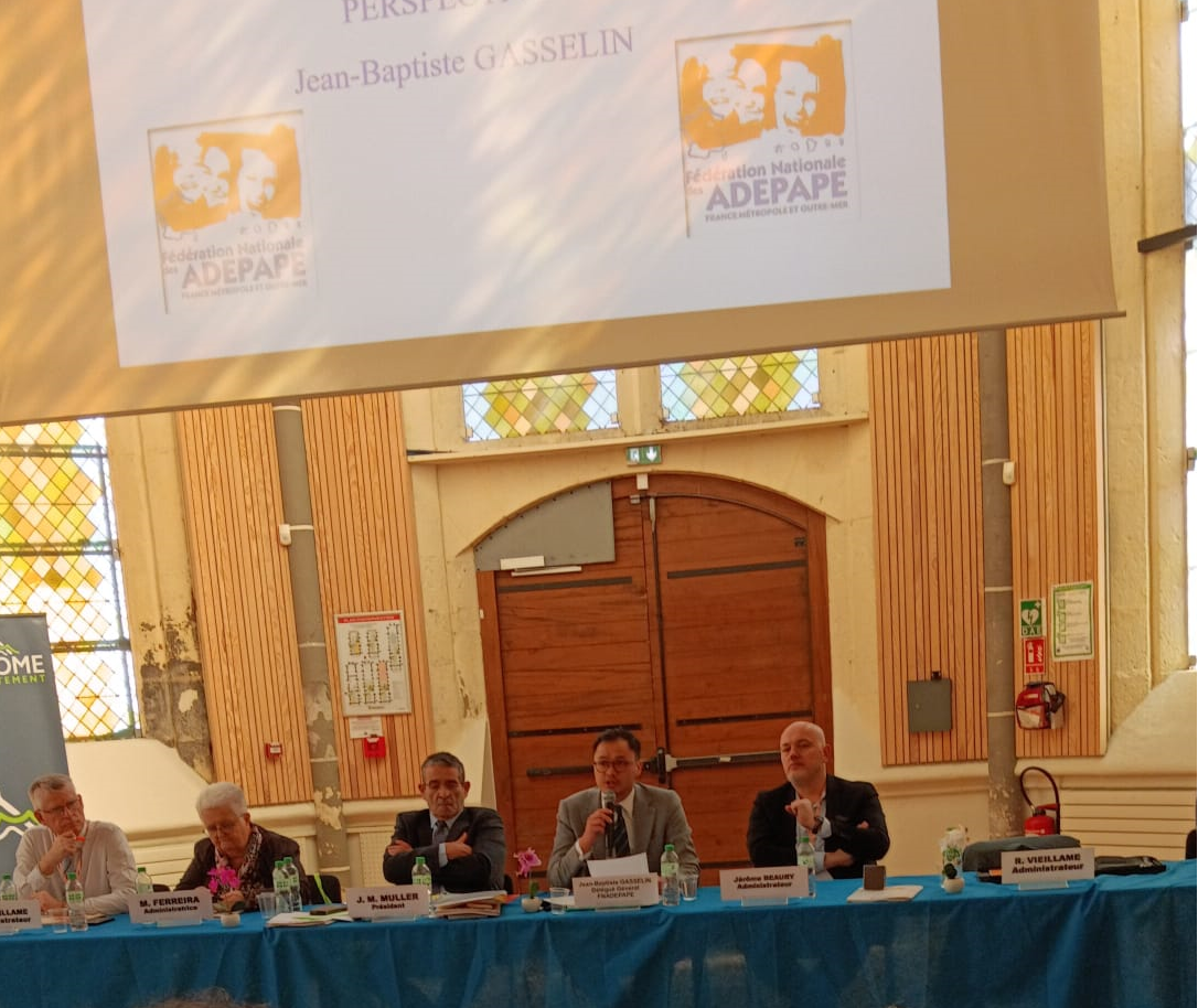 Les intervenants à la table du congrès devant un écran de projection.