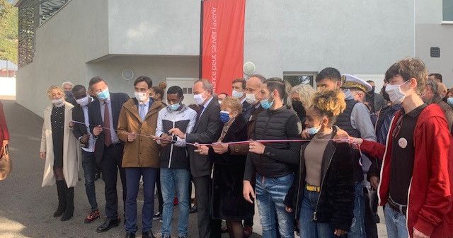 Des participants coupent un ruban lors de l’inauguration de la résidence.
