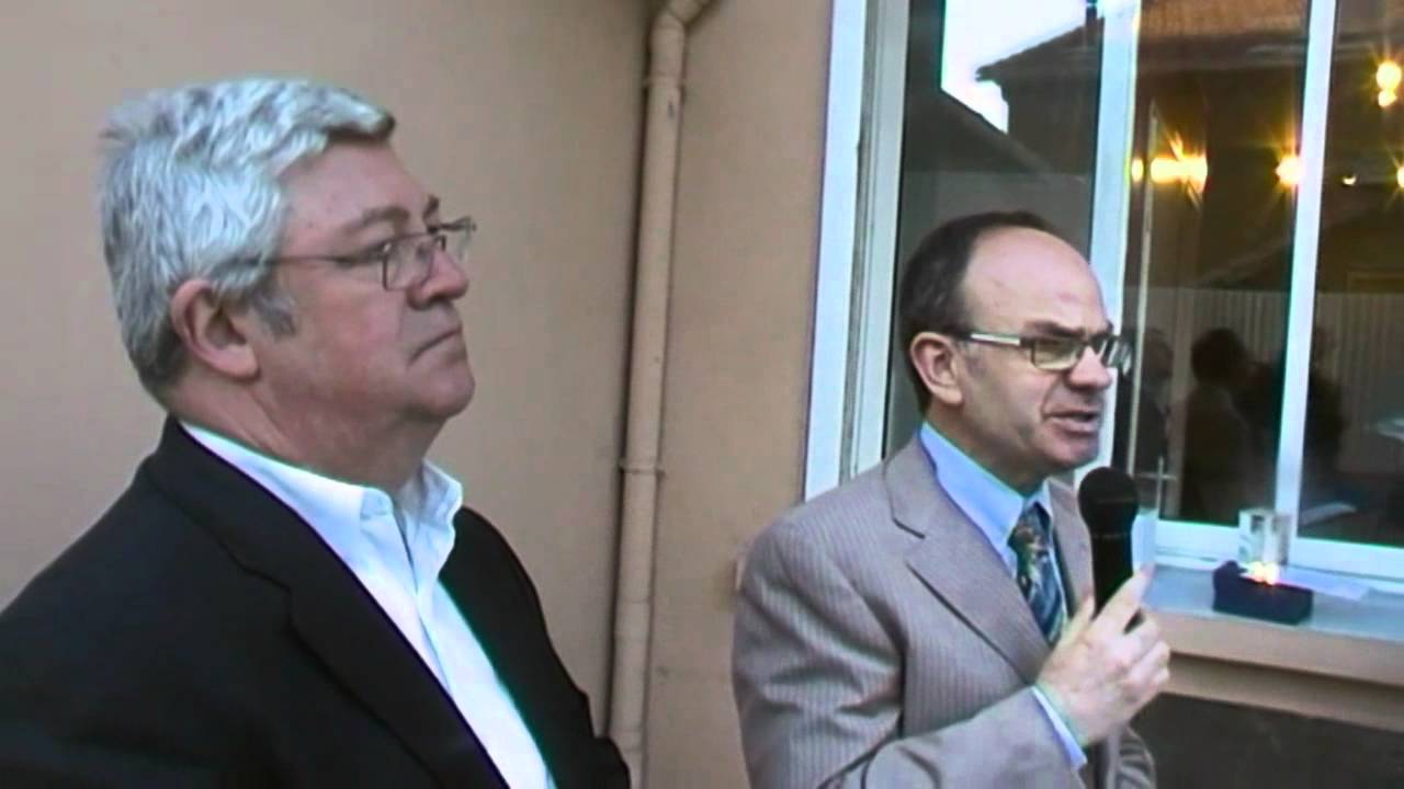 Deux intervenants devant un microphone lors de la cérémonie de 2012.
